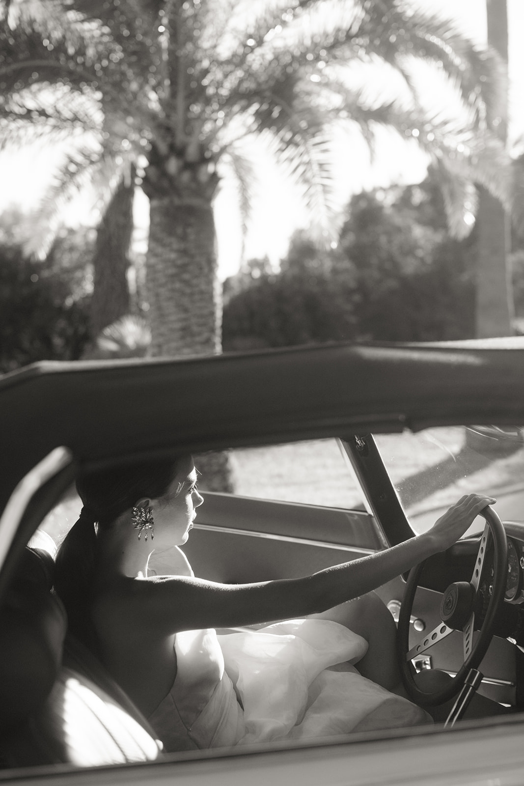 Black-and-white bridal portrait driving a classic Jaguar near Saint-Tropez